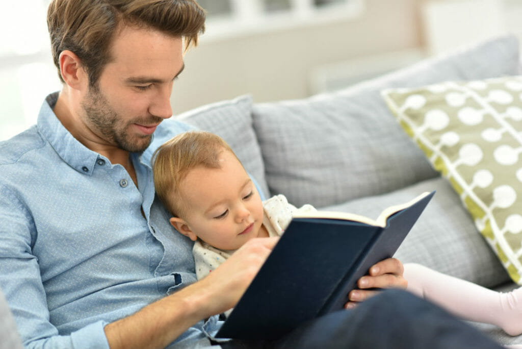 Father and child reading a book | Fathers Moving Forward Scholarship