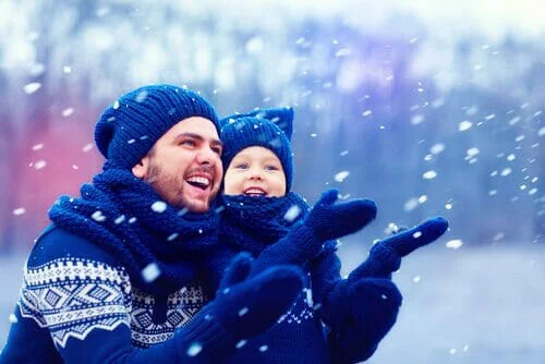 A joyful father playing with son on the snow
